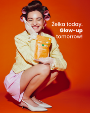Uśmiechnięta dziewczyna w wałkach na głowie kuca na pomarańczowym tle i trzyma opakowanie żelek so lovely. Obok napis: żelka today. Glow-up tommorow!